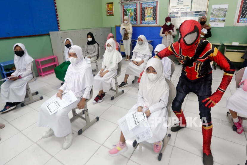  Siswa sekolah dasar ditemani oleh seorang pria yang mengenakan kostum Spiderman menunggu giliran untuk menerima dosis vaksin sinovac selama upaya vaksinasi covid-19 untuk anak-anak antara usia enam hingga 11 tahun, di sebuah sekolah dasar Islam Al-Ashar di Tangerang, Senin (17/1) dini hari WIB. Beberapa provinsi di Indonesia salah satunya Banten berlomba-lomba menyuntik vaksin untuk anak usia 6-11 tahun, guna mencapai imunitas komunal dan mempercepat penyerapan vaksin.