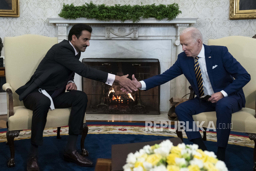  Presiden Joe Biden, kanan, berjabat tangan dengan Emir Qatar Sheikh Tamim bin Hamad Al Thani di Kantor Oval Gedung Putih, Senin, 31 Januari 2022, di Washington.