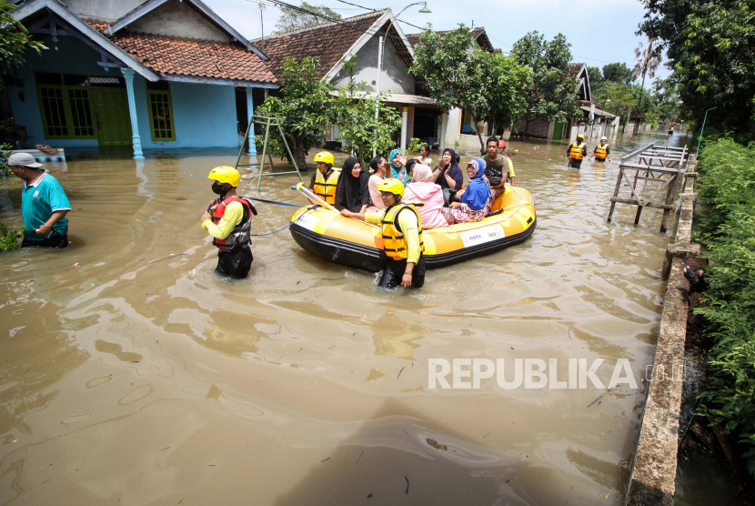 Petugas mengevakuasi warga terdampak banjir di Desa Rejoso, Kecamatan Rejoso, Pasuruan, Jawa Timur, Rabu (19/1/2022). Menurut data Badan Penanggulangan Bencana Daerah (BPBD) Kabupaten Pasuruan, sebanyak 5.017 Kepala Keluarga (KK) di enam kecamatan terdampak banjir akibat luapan Sungai Rejoso. 