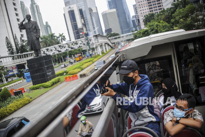 Penumpang memotret saat menaiki bus wisata yang dioperasikan PT Transjakarta di Jakarta, Selasa (10/5/2022). 