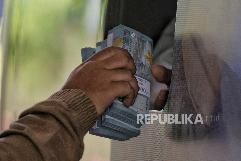 Warga melakukan penukaran uang rupiah baru di mobil kas keliling Bank Indonesia (BI).