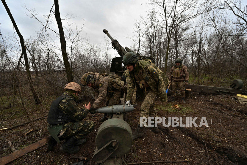 Prajurit Ukraina menyiapkan peluru untuk howitzer 2A65 Msta-B sebelum menembak ke arah pasukan Rusia, di tengah serangan Rusia terhadap Ukraina, di garis depan di wilayah Zaporizhzhia, Ukraina, Kamis (5/1/2023). 