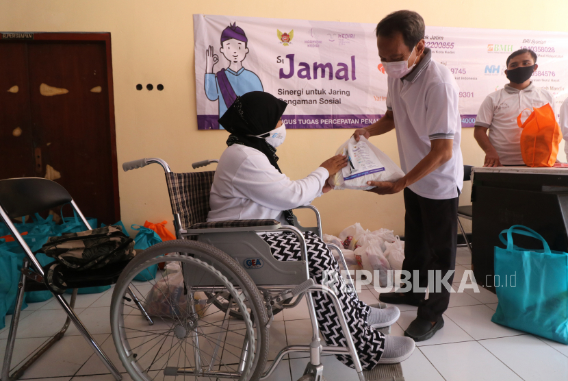 Warga penyandang disabilitas mengambil bantuan sosial Si Jamal (Sinergi untuk Jaring Pengaman Sosial) di Kantor Dinas Sosial Kota Kediri, Jawa Timur, Jumat (1/5/2020). Si Jamal merupakan kolaborasi pemerintah daerah setempat dengan delapan lembaga amal yakni Badan Amal Zakat Nasional, Rumah Zakat Indonesia, Yatim Mandiri, Baitul Maal Hidayatullah, Nurul Hayat, LMI, Sahabat Mustahiq dan Al Haromah untuk menghimpun donasi dari masyarakat yang kemudian disalurkan kepada warga terdampak pandemi COVID-19 dalam bentuk sembako