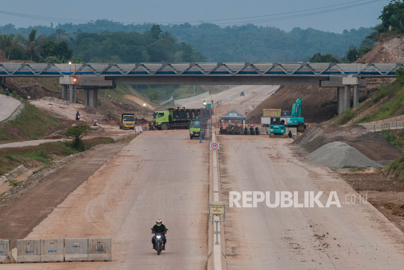 Pekerja melintas di proyek pembangunan jalan tol Serang - Panimbang di Desa Cikeusal, Kabupaten Serang, Banten, Jumat (3/7/2020). PT Wijaya Karya menjelaskan progres pembangunan jalan tol seksi I Serang sampai Cileles telah mencapai 71 persen dan ditargetkan mulai beroperasi tahun 2021 mendatang. 