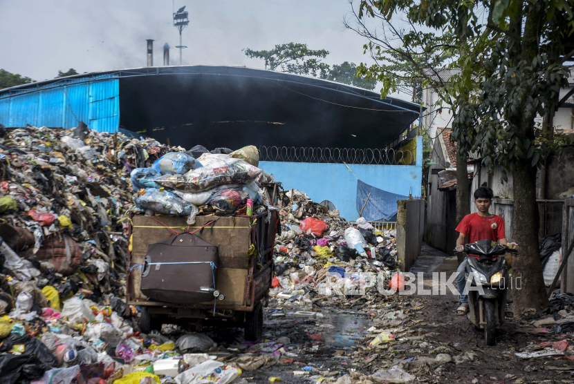 Pengendara melintas di samping Tempat Pembuangan Sampah Sementara (TPS) Ciwastra yang ditutup sementara di Rancasari, Kota Bandung, Jawa Barat.
