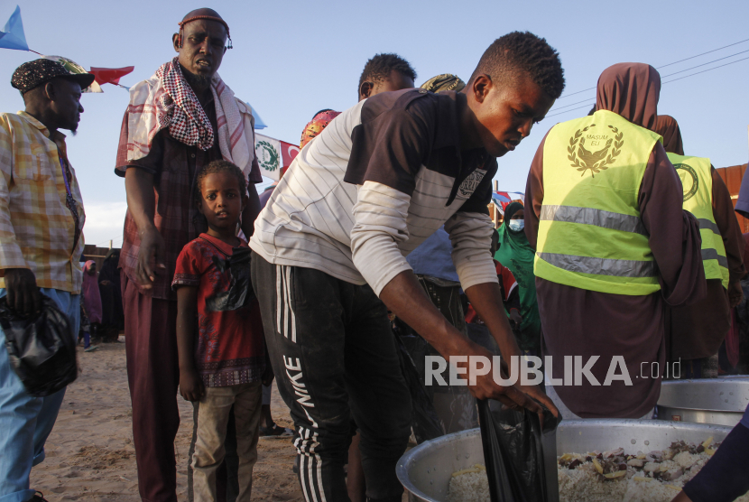 Sejumlah warga mengantre untuk mendapatkan makanan berbuka puasa di salah satu tempat pengungsian, Mogadishu, Somalia Jumat (16/4). Di bulan suci Ramadhan, pengungsi internal ini mengandalkan bantuan makanan untuk bertahan hidup. Mogadishu yang merupakan Ibu Kota Somalia itu adalah rumah bagi lebih dari setengah juta pengungsi internal yang tinggal di tempat pengungsian padat dengan sanitasi yang buruk dan beresiko menyebarkan virus Corona. (AP Photo/Farah Abdi Warsameh)