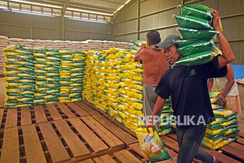 Pekerja mengangkut stok beras kualitas medium kemasan 5 kilogram di gudang Bulog Serang, Banten, Senin (31/7/2023). 