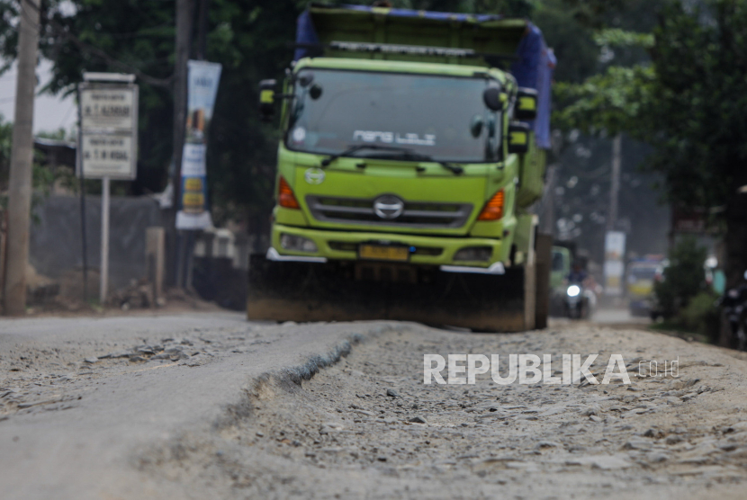 Truk melintasi jalan yang rusak di Jalan Sudamanik, Parung Panjang, Kabupaten Bogor, Jawa Barat, Senin (20/11/2023). Kondisi jalan yang rusak serta berlubang dan keberadaan truk muatan tambang yang beroperasi pada jam yang belum ditentukan tersebut dapat membahayakan keselamatan pengendara lain.
