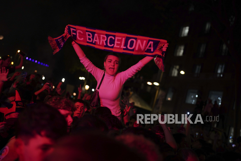Fans Barcelona merayakan di jalan setelah tim mereka memenangkan kejuaraan La Liga Spanyol dengan mengalahkan rival sekota Espanyol di Barcelona, Spanyol, Senin (15/5/2023) dini hari WIB.