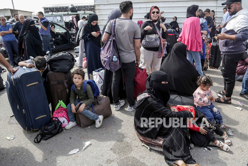 Warga Palestina dengan kewarganegaraan ganda menunggu untuk melintasi perbatasan Rafah dengan Mesir, Jalur Gaza selatan, Senin (16/10/2023).