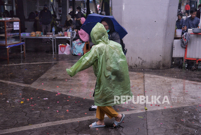 Warga mengenakan jas hujan untuk beraktivitas di Stasiun Tebet, Jakarta, Selasa (30/1/2024).