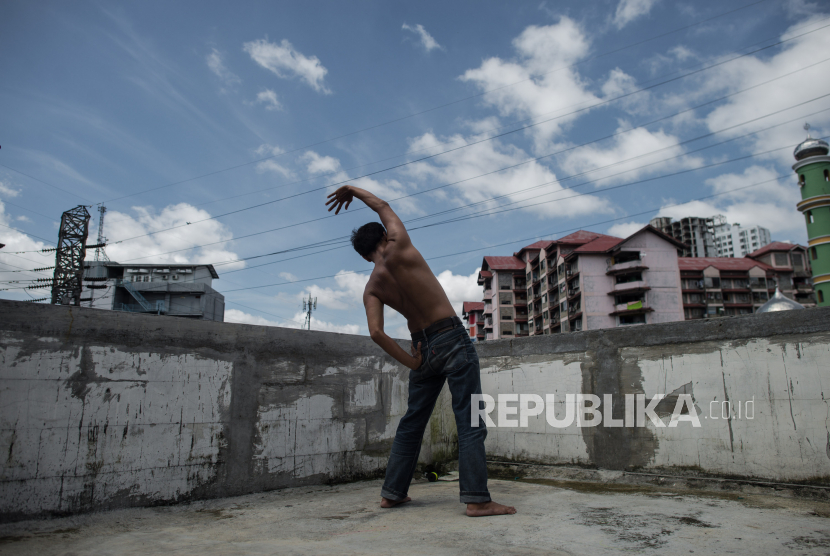 Warga berjemur di balkon rumahnya di kawasan pemukiman padat ditengah pandemi COVID-19, Jakarta, Selasa (7/4). Aktifitas berjemur dan berolahraga dipercayai warga dapat mengantisipasi penyebaran COVID-19