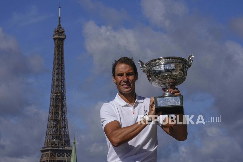 Petenis Spanyol Rafael Nadal berpose dengan pialanya di jembatan Alexander III di Paris, Senin, 6 Juni 2022, setelah ia memenangkan pertandingan final putra hari Minggu di turnamen tenis Prancis Terbuka di stadion Roland Garros.