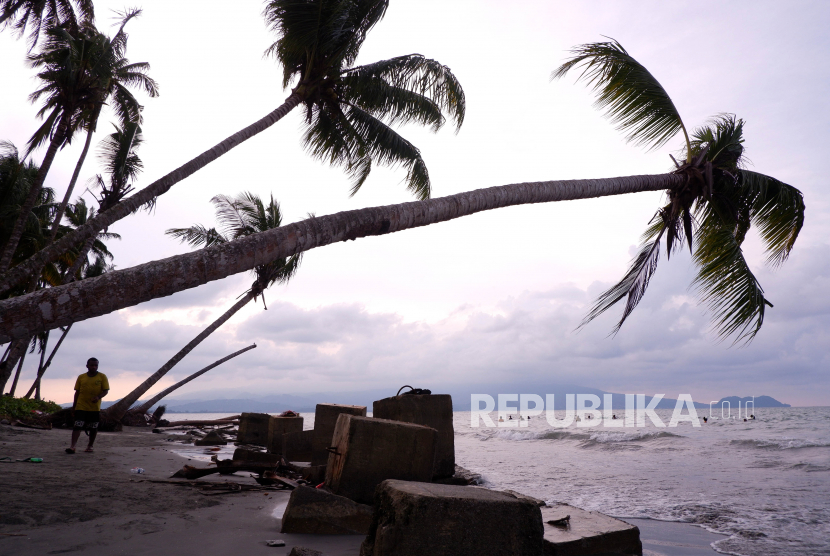 Pengunjung berjalan di bibir pantai di Distrik Muara Tami, Kota Jayapura, Papua, Jumat (26/8/2022).
