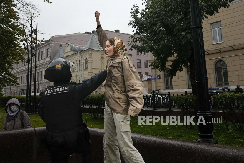 Seorang petugas polisi menahan seorang demonstran selama protes terhadap mobilisasi parsial di Moskow, Rusia, Sabtu, 24 September 2022. Penahanan perempuan dalam protes terhadap mobilisasi Presiden Vladimir Putin untuk perang di Ukraina telah meningkat. Para laki-laki kebanyakan merasa takut dikirim ke garis depan jika mereka berdemonstrasi.