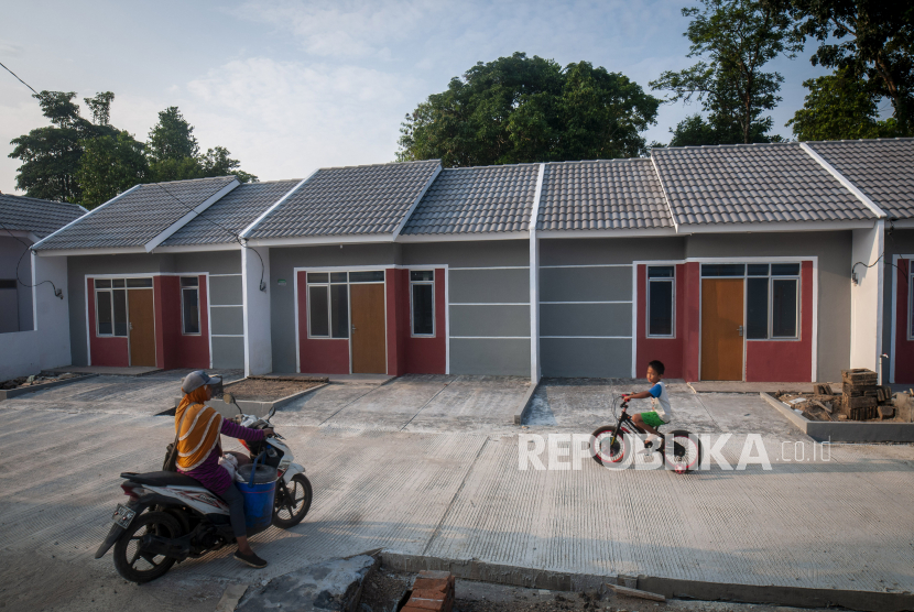 Warga melintas di salah satu kompleks perumahan bersubsidi di Pandeglang, Banten, Senin (11/7/2022). Pemerintah melalui program Fasilitas Likuiditas Pembiayaan Perumahan (FLPP) menargetkan sebanyak 200 ribu unit rumah bersubsidi akan dibangun di tahun 2022 bagi masyarakat berpenghasilan rendah (MBR) agar dapat memiliki hunian yang layak huni dengan harga yang terjangkau. 