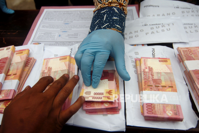 Personel kepolisian menunjukkan barang bukti uang palsu saat gelar kasus di Polres Brebes, Jawa Tengah, Kamis (15/10/2020).