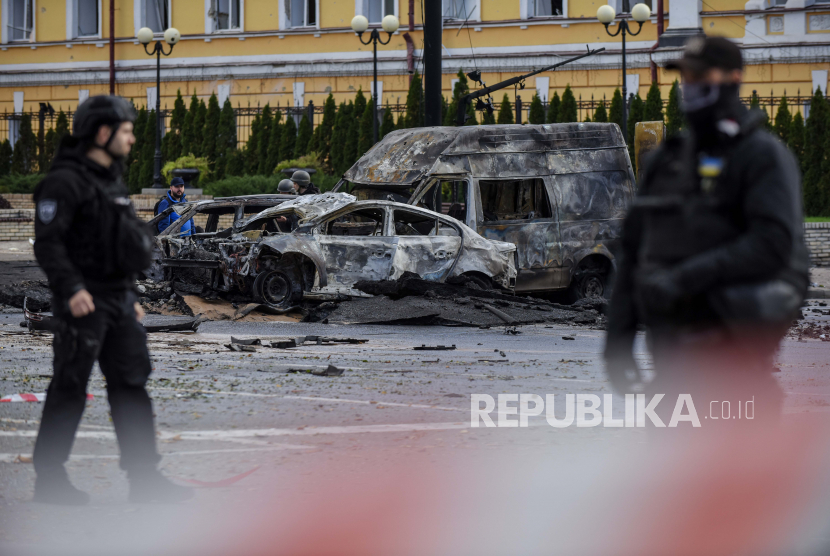  Petugas polisi berjaga di dekat mobil yang hancur setelah penembakan di pusat kota Kyiv (Kiev), Ukraina, 10 Oktober 2022. Komite Palang Merah Internasional (ICRC) dan satu lembaga kemanusiaan lainnya menghentikan sementara kerja lapangan di Ukraina atas alasan keamanan.