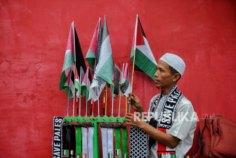 Pedagang menjual pernak pernik bendera Palestina saat aksi solidaritas global untuk Gaza di depan Kedubes Amerika Serikat, Jakarta, Sabtu (13/1/2024). 