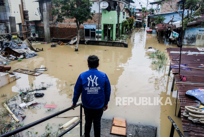  Seorang pria melihat kawasan pemukiman yang terendam banjir di Medan, Sumatera Utara, 5 Desember 2020.