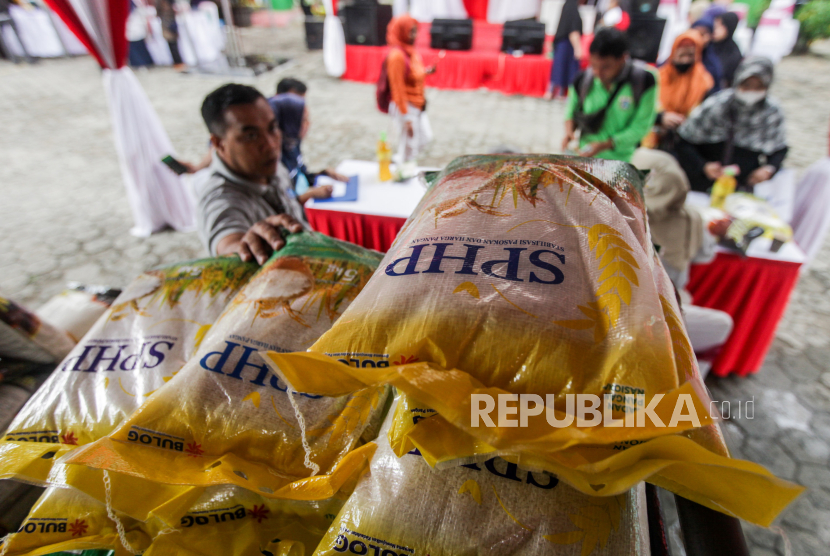 Petugas menurunkan beras yang dijual saat bazar pasar murah di Kantor Kecamatan Pancoran, Jakarta, Senin (26/2/2024).