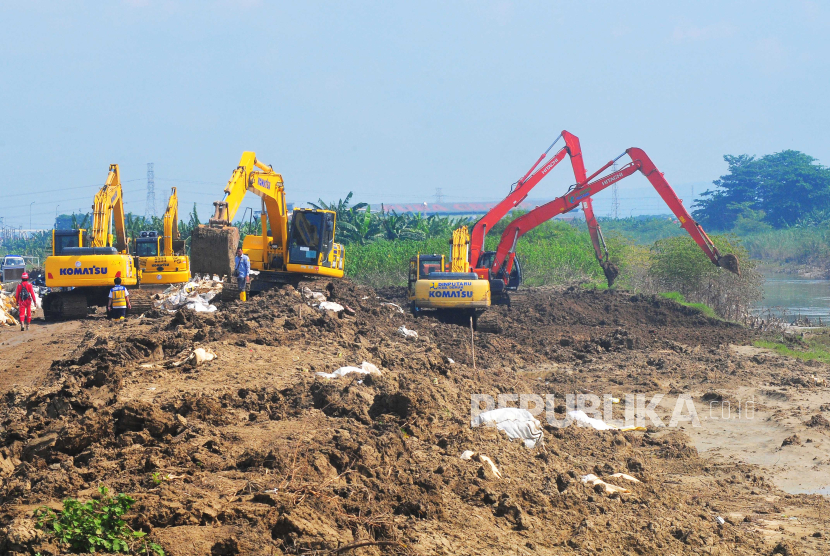 Pekerja menggunakan alat berat saat memperbaiki tanggul Sungai Wulan yang jebol di Desa Ketanjung, Karanganyar, Kabupaten Demak, Jawa Tengah, Jumat (22/3/2024). 
