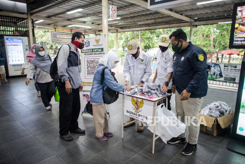 Petugas Badan Amil Zakat Nasional (BAZNAS) memberikan masker gratis kepada calon penumpang KRL di Stasiun Manggarai, Jakarta, Rabu (8/4). kegiatan tersebut dilakukan sebagai bentuk peduli bagi penumpang KRL untuk tetap mengantisipasi penyebaran virus COVID-19 dengan menggunakan masker di tempat umum