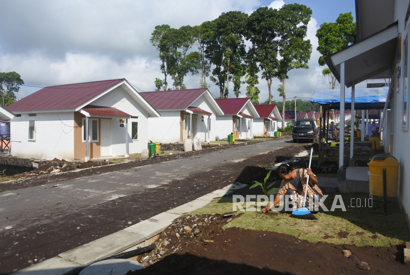 Warga penyintas bencana awan panas guguran (APG) Gunung Semeru membersihkan halaman hunian tetap di Desa Sumbermujur, Candipuro, Lumajang, Jawa Timur. 