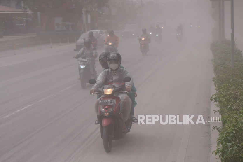 Sejumlah pengendara sepeda motor melintas di jalan utama kota Magelang yang diselimuti abu vulkanis gunung Merapi di Magelang, Jawa Tengah, Sabtu (11/3/2023). Gunung Merapi kembali memuntahkan awan panas guguran (APG) pada pukul 12.12 WIB yang mengakibatkan hujan abu yang mengarah ke barat laut dan utara, hujan abu dengan intensitas tinggi terjadi di Kota Magelang. 