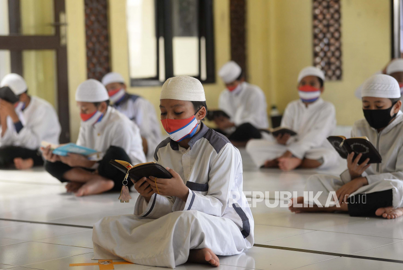 Sejumlah santri pesantren Daarul Quran Al Kautsar, Cibinong, Bogor, Jawa Barat membaca Al-quran secara bersama-sama dengan menerapkan jaga jarak dan menggunakan masker, Kamis (7/5). Kegiatan mengkhatamkan Al Quran tersebut rutin dilaksanakan pada bulan ramadhan