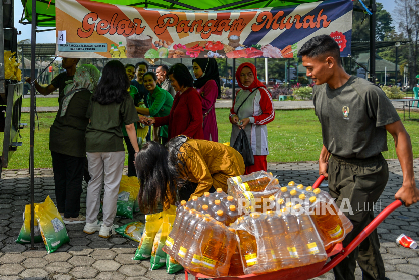 Petugas membawa minyak goreng untuk dijual saat gelar pangan murah di Lapangan Yonzipur 9, Ujung Berung, Bandung, Jawa Barat, Jumat (29/12/2023).
