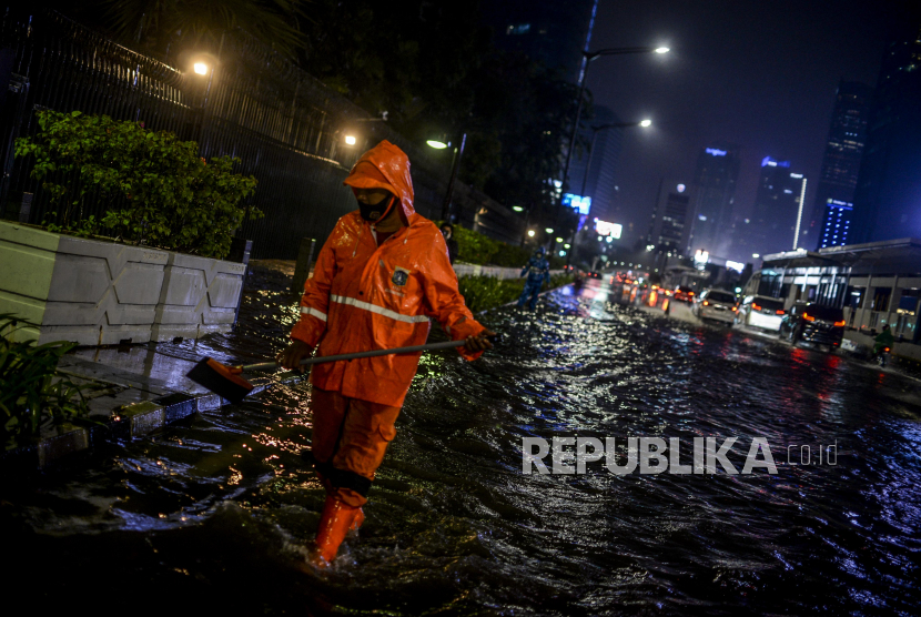 Petugas PPSU membersihkan saluran air dari sampah di kawasan Bundaran HI, Jakarta, Senin (21/9). Hujan deras yang mengguyur wilayah Ibu Kota menyebabkan genangan air di sejumlah jalan protokol sehingga menghambat laju kendaraan yang melintas. Republika/Putra M. AKbar