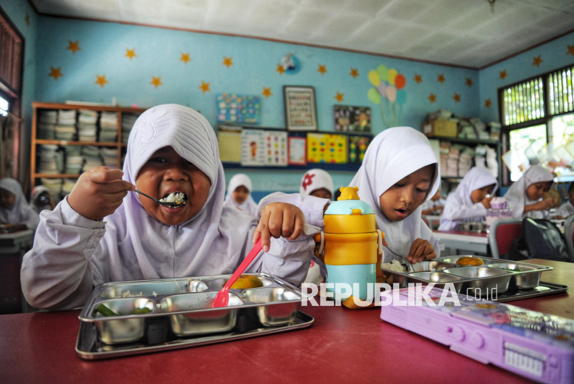 Para siswa menyantap hidangan Makan Bergizi Gratis (MBG) di SDN 05 Sukatani, Depok, Jawa Barat, Senin (6/1/2025). Pada hari pertama program makan bergizi gratis (MBG) tersebut para siswa terlihat antusias menikmati menu makanan. Total sebanyak 406 para siswa kelas 1 hingga kelas 6 menikmati paket menu makanan uang teridiri dari Nasi, Daging Ayam, Tempe, Sayur Buncis dan Buah Jeruk. Salah satu siswa kelas 5 Fatah Ar Rozak mengaku senang mendapatkan makan bergizi gratis dari program pemerintah tersebut. Menurutnya rasa makanannya enak dan untuk porsi makanannya cukup mengenyangkan.