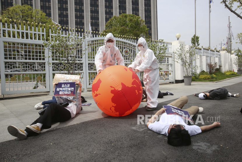 Aktivis lingkungan dengan balon bumi melakukan aksi mati-matian dalam unjuk rasa memperingati Hari Bumi melawan perubahan iklim di depan Kompleks Pemerintah di Seoul, Korea Selatan, Kamis, 22 April 2021.