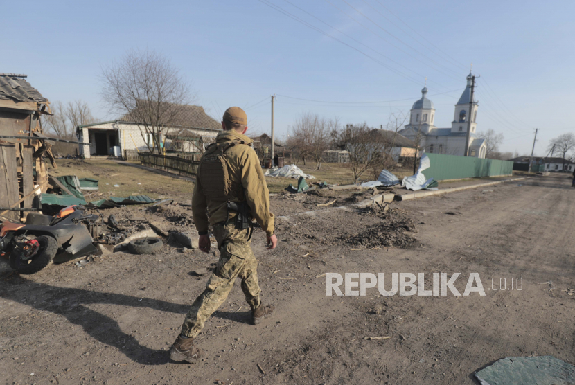  Seorang tentara Ukraina berjalan di jalan setelah pertempuran, di daerah yang sekarang dibebaskan dari pasukan Rusia, tidak jauh dari Kyiv (Kiev), Ukraina, 28 Maret 2022. Sejumlah kota Ukraina berencana untuk mengganti nama jalan dan alun-alun yang terkait dengan Rusia.