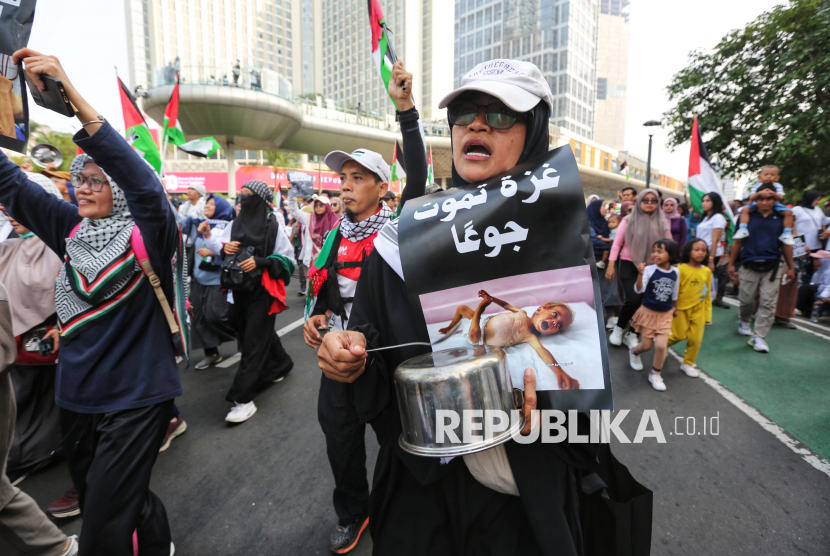 Sejumlah massa melakukan aksi longmarch lawan genosida di Gaza saat melintas di kawasan Bundaran HI, Jakarta, Ahad (27/7/2025). Dalam aksi yang berlangsung damai ini, para peserta aksi membawa alat makan dan alat masak sebagai simbol solidaritas terhadap kondisi kelaparan yang dialami warga Gaza. Saat ini di Gaza sedang terjadi krisis kemanusiaan akut dengan bahaya kelaparan yang menimpa sebagian besar warganya. Massa juga menyerukan penghentian genosida yang terjadi.