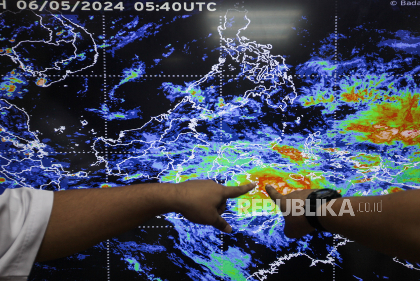 Petugas Badan Meteorologi, Klimatologi dan Geofisika (BMKG) memberikan penjelasan pada layar yang menampilkan citra satelit cuaca di Kantor BMKG, Jakarta.