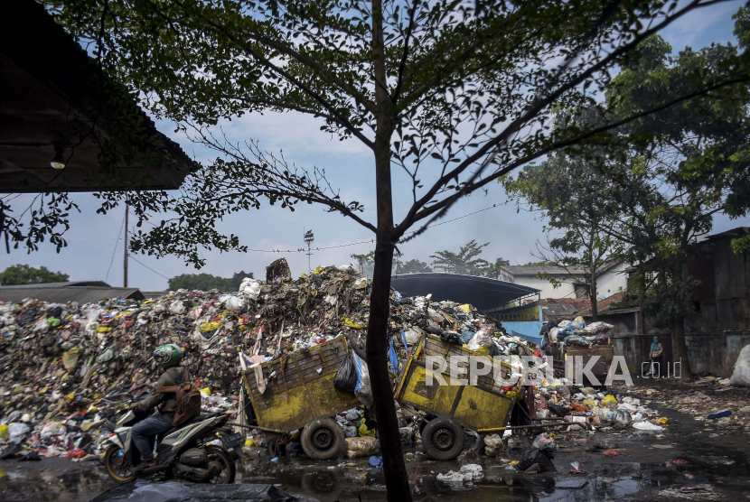 Pengendara melintas di depan Tempat Pembuangan Sampah Sementara (TPS) -- ilustrasi