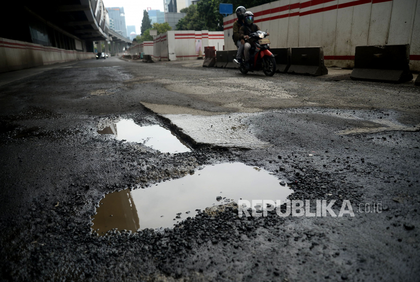 Kendaraan melewati jalan yang rusak di Jalan Rasuna Said, Kuningan, Jakarta, Ahad (13/2/2022). Salah satu jalan protokol ibukota tersebut mengalami kerusakan berlubang hingga bergelombang sehingga dapat membahayakan keselamatan pengendara. 