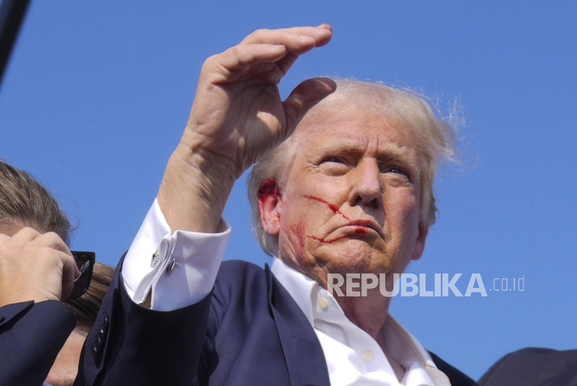 Kandidat presiden dari Partai Republik yang juga mantan Presiden Donald Trump menuruni turun panggung usai ditembak saat kampanye di Butler, Pennsylvania, AS, Sabtu (13/7/2024). Kandidat Presiden dari Partai Republik Donald Trump terluka usai suara tembakan terdengar di tengah kampanye di Pennsylvania. Meskipun terluka, Trump dipastikan dalam kondisi baik.