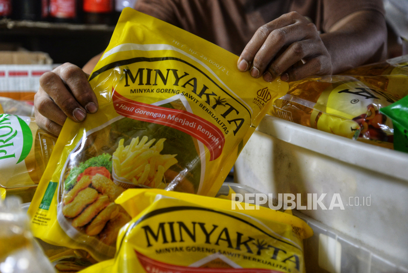 Pedagang menunjukan Minyakita di sebuah warung klontong di Jakarta, Senin (22/7/2024). 