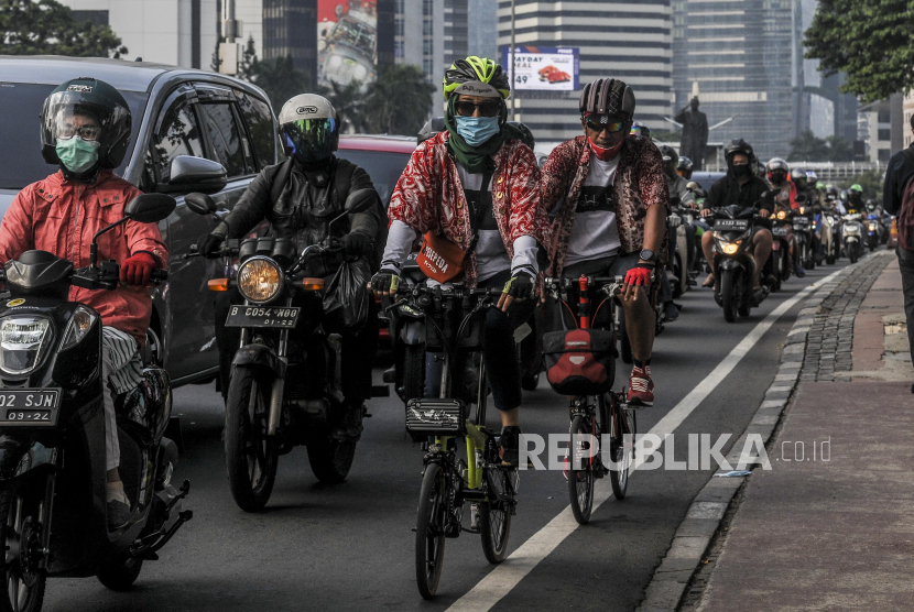 Pesepeda menggunakan busana batik saat melintas di kawasan Sudirman, Jakarta, Jumat (2/10). Pemakaian busana batik itu sebagai salah satu cara memperingati Hari Batik Nasional yang jatuh setiap tanggal 2 Oktober. Republika/Putra M. Akbar