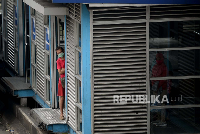 Penumpang menunggu keberangkatan bus transjakarta saat pemberlakuan Pembatasan Sosial Berskala Besar (PSBB) pada hari ke dua di Halte Harmoni, Jakarta, Sabtu (11/4). DKI Jakarta masih menjadi pusat episentrum COVID-19 di Indonesia