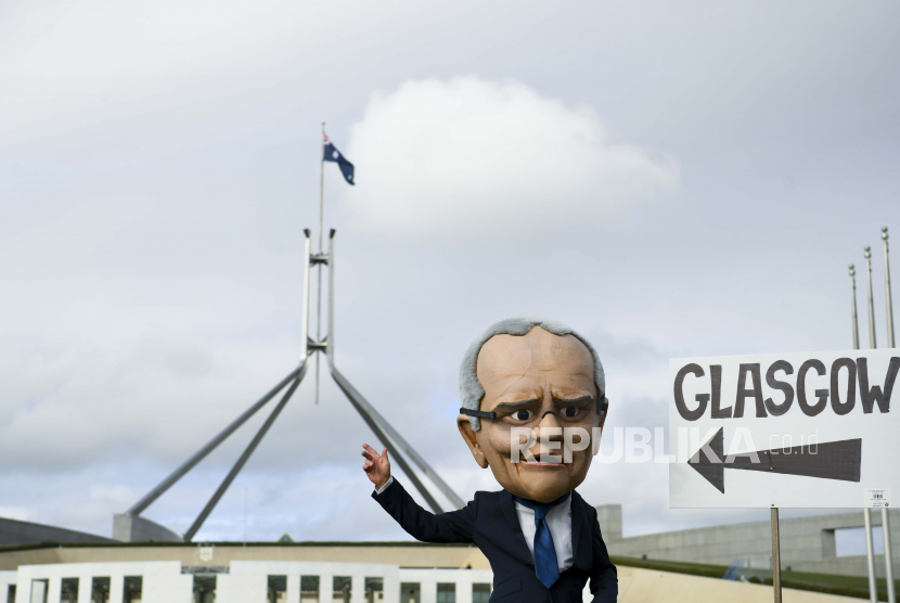  Seorang aktivis lingkungan mengenakan topeng yang menggambarkan Perdana Menteri Australia Scott Morrison mengambil bagian dalam protes perubahan iklim di luar Gedung Parlemen di Canberra, Wilayah Ibu Kota Australia, Australia, 21 Oktober 2021. Satu dari tiga orang pegawai parlemen Australia pernah mengalami pelecehan seksual.