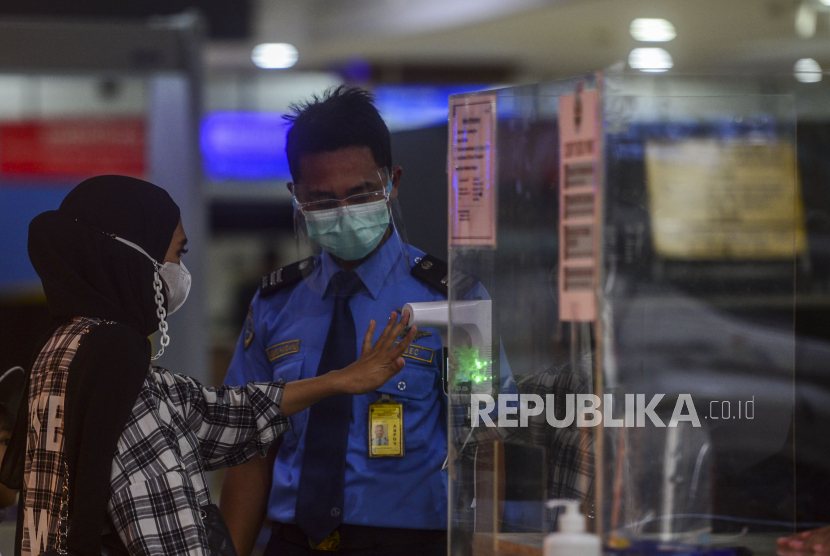 Sejumlah calon penumpang diperiksa suhu tubuhnya di Bandara Halim Perdanakusma, Jakarta Timur, Sabtu (20/3). Sebanyak 13 penerbangan di Bandara Halim Perdanakusuma terpaksa dialihkan ke Bandara Internasional Soekarno Hatta imbas dari insiden tergelincirnya pesawat Trigana Air Boeing 737-500 di Bandara Halim Perdanakusuma. Republika/Putra M. Akbar