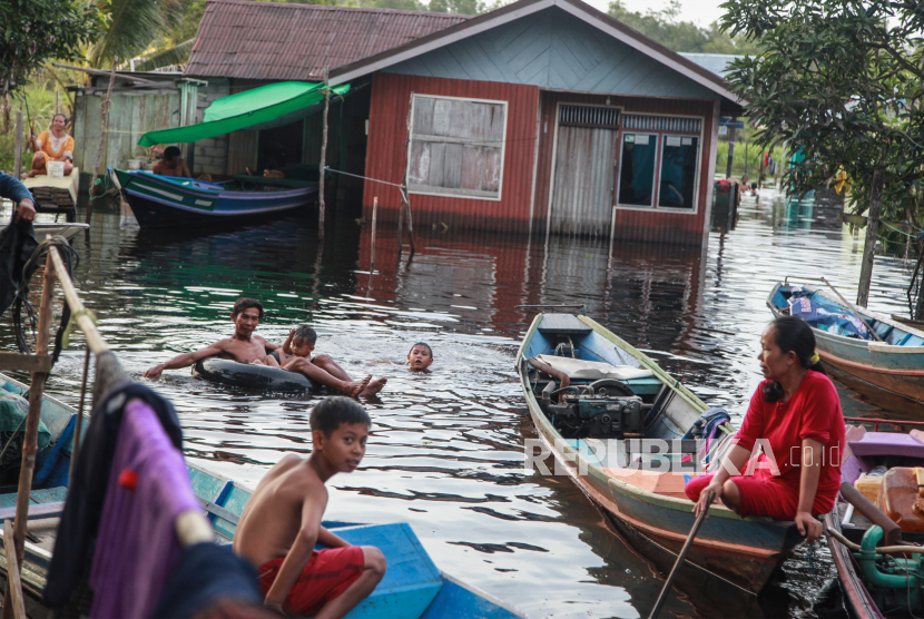 Warga bermain di sekitar rumahnya yang terendam banjir di Kelurahan Karanganyar, Kotawaringin Barat, Kalimantan Tengah, (ilustrasi).