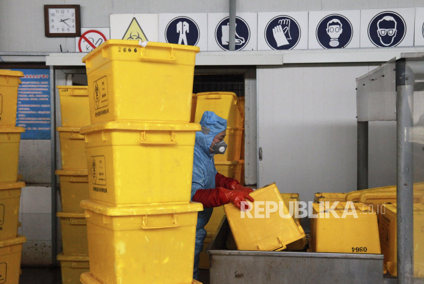 Pekerja mengangkut kotak pembuangan limbah medis, termasuk limbah alat pelindung diri (APD). ilustrasi