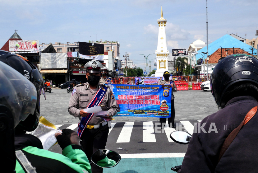 Petugas Satlantas Polresta Yogyakarta memberikan imbauan, pamflet, dan membagikan masker kepada pengendara saat Operasi Zebra Progo 2021 di Tugu Pal Putih, Yogyakarta.