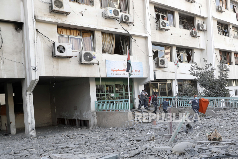  FILE - Dalam file foto 17 Mei 2021 ini, petugas medis memeriksa puing-puing klinik perawatan kesehatan Gaza setelah serangan udara Israel di lantai atas sebuah bangunan komersial dekat Kementerian Kesehatan di Kota Gaza.