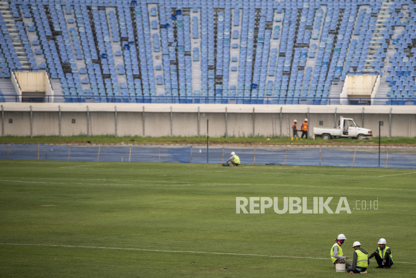 Pekerja merawat rumput lapangan sepak bola saat renovasi Stadion Si Jalak Harupat di Soreang, Kabupaten Bandung, Jawa Barat, Sabtu (11/3/2023). Renovasi Stadion Si Jalak Harupat tersebut ditujukan untuk perhelatan Piala Dunia U-20 pada Mei hingga Juni 2023 mendatang. 